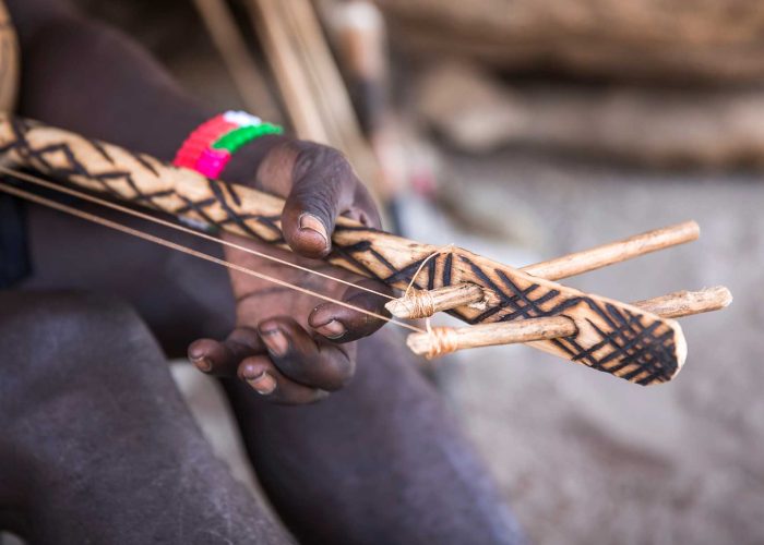 Artisan Hadzabe sculptant une arme traditionnelle